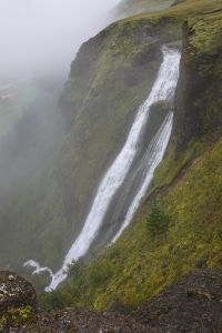 Vodopád Systrafoss v mlze je přímo v městečku Kirkjubæjarklaustur.