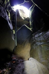 Slézáme po žebřících do jeskyně.